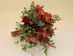 An informal bridal bouquet in red tones