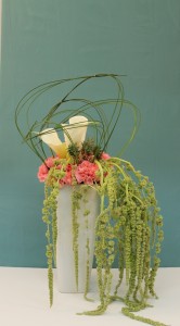 Tall vase arrangement with roses, hanging amaranthus and pineapple