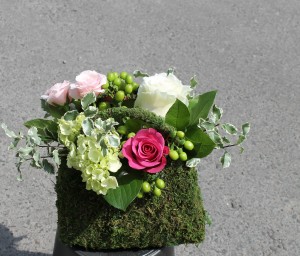 Pink, white and green arrangement in a purse