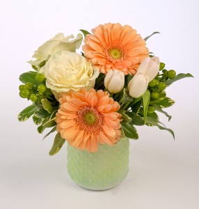 Peach gerbera, white roses in a mint glass hobnail jar